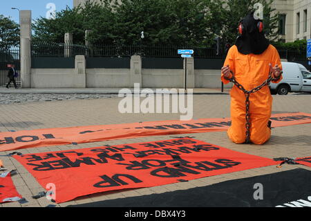 Londra, Regno Unito. 5 agosto 2013. Veglia di protesta per Shaker Aamer, ultimo cittadino del Regno Unito a Guantanamo, indossando tute arancioni una catena con le braccia e le gambe al di fuori a MI6 di Londra. Credito: Vedere Li/Alamy Live News Foto Stock