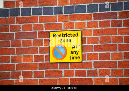 Zona riservata, nessun parcheggio in qualsiasi momento segno su muro di mattoni a Weymouth, Dorset Regno Unito nel mese di marzo Foto Stock