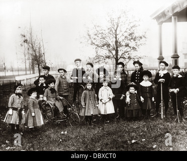 1890s 1900 PONE Ritratto di gruppo di 18 Giro del 20esimo secolo quartiere bambini assemblato nella zona suburbana di cortile anteriore Foto Stock