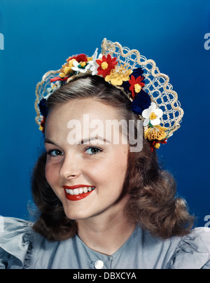 Negli anni quaranta anni cinquanta ritratto sorridente ragazza TEEN INDOSSANDO LACE HAT CON FIORI IN TESSUTO Foto Stock