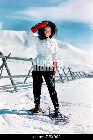 Negli anni quaranta anni cinquanta donna sorridente PASSEGGIATE CON LE RACCHETTE DA NEVE Foto Stock