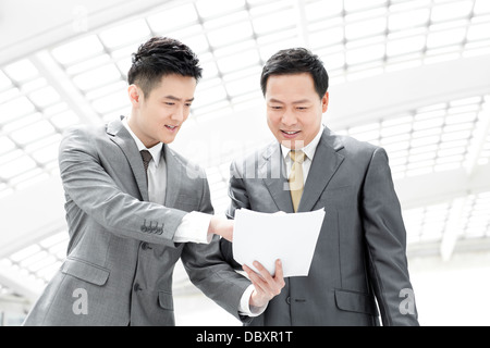 Partner commerciali con un file nella lobby di airport Foto Stock