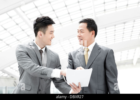 Partner commerciali con un file nella lobby di airport Foto Stock