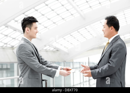 Soci di affari lo scambio di business card nella lobby di airport Foto Stock