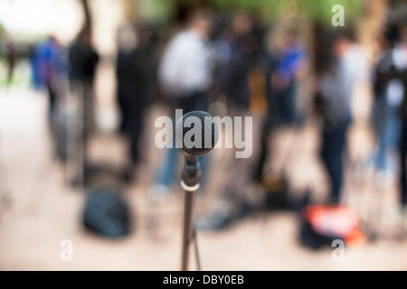 Microfono a fuoco contro pubblico sfocata Foto Stock