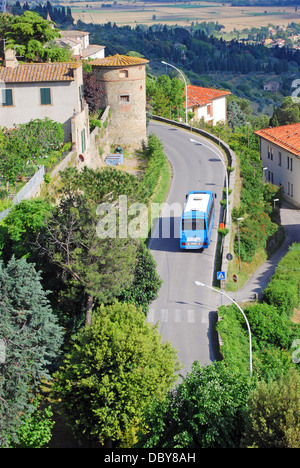 Un autobus su una strada tortuosa avvicinando Pienza nelle colline toscane di Italia Foto Stock