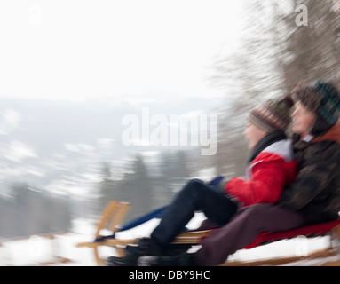 Sfocata vista del movimento dei ragazzi slittino nella neve Foto Stock