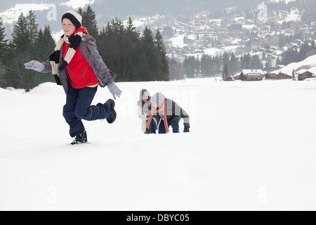 Madre e figli giocare nel campo nevoso Foto Stock