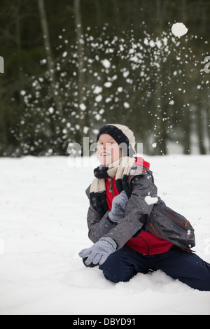 Ritratto di felice ragazzo godendo lotta con le palle di neve Foto Stock