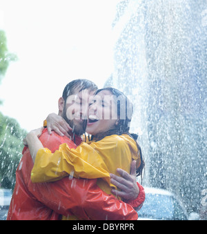 Coppia felice costeggiata in Rain Foto Stock