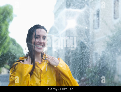 Entusiastico donna in piedi sotto la pioggia Foto Stock