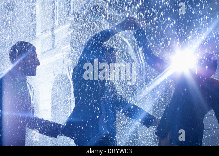 Imprenditori dancing in Rain Foto Stock