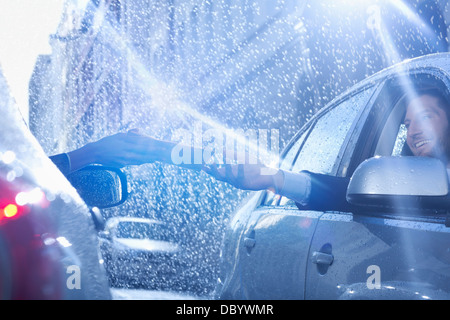 Imprenditore in auto per raggiungere la documentazione in caso di pioggia Foto Stock