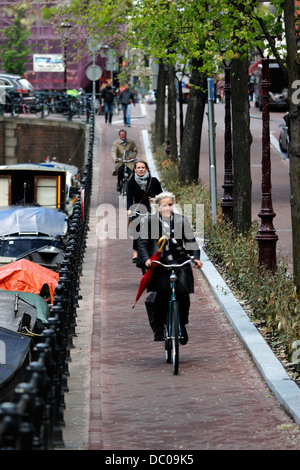 Amsterdam Paesi Bassi Olanda Europa il trasporto biciclette scooter lungo Canal Foto Stock