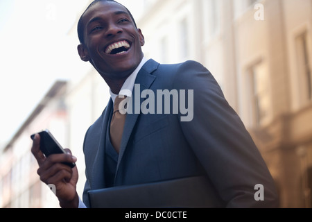 Imprenditore entusiasta per la messaggistica di testo con un telefono cellulare Foto Stock