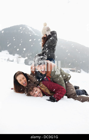 Giocoso amici godendo lotta con le palle di neve nel campo Foto Stock