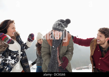 Giocoso amici godendo lotta con le palle di neve Foto Stock