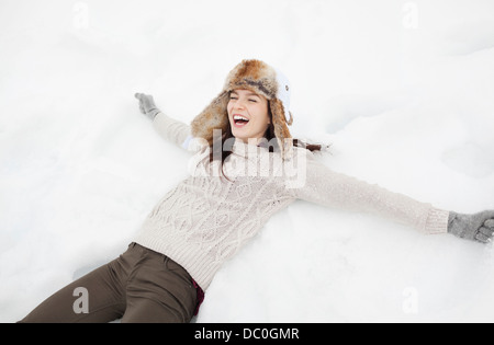 Donna entusiasta rendendo angelo di neve Foto Stock