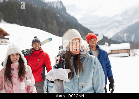 Happy amici il trasporto di sci in campo nevoso Foto Stock