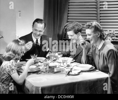 1930s 1940s famiglia felice di mangiare la cena a casa Foto Stock