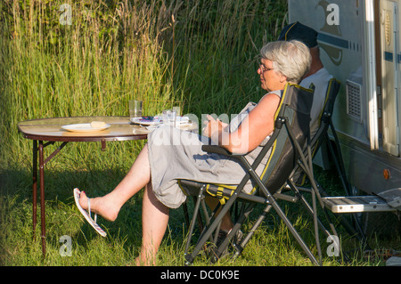 Coppia di anziani seduti al di fuori della loro motorhome sull'Aire de camping, nella cittadina costiera di Le Crotoy, dipartimento della Somme, in Piccardia, nella Francia settentrionale. Foto Stock