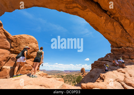 I turisti alla finestra del Nord arch, Sezione Windows, Arches National Park, Utah, Stati Uniti d'America Foto Stock