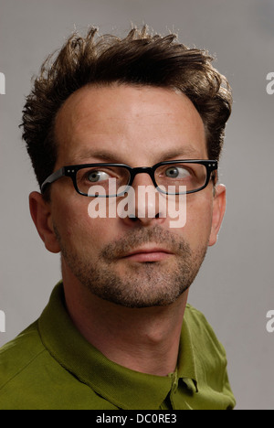Un uomo con gli occhiali, una verde Polo shirt e barba lunga Foto Stock