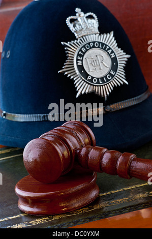 Casco della polizia metropolitana con il martelletto dei giudici nei tribunali di Londra Concept Situation UK Foto Stock