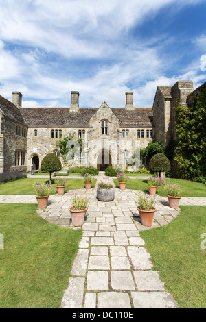 Nymans, una country house a Haywards Heath, West Sussex, in Inghilterra in estate con giardino formale, percorso di pietra e vasi per fiori Foto Stock