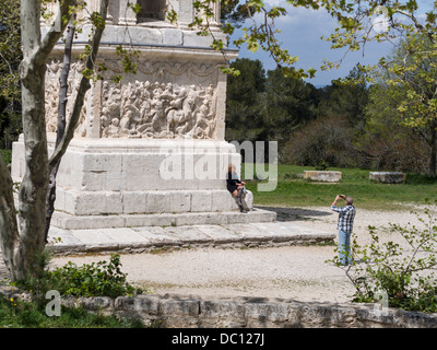 I turisti scattare una fotografia al mausoleo di Glanum . Una donna con alti stivali in posa per una fotografia di fronte all'antica hi Foto Stock