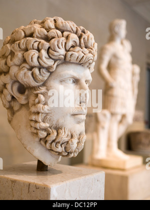 Vista laterale di un Busto di imperatore romano Lucius Verus. Sullo sfondo sono altre statue romane in marmo bianco. Foto Stock