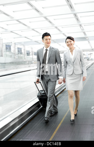 Colleghi di lavoro con i bagagli in aeroporto escalator Foto Stock