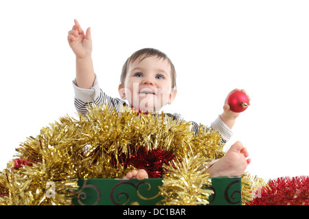 Graziosa bambina all'interno di una scatola con ornamenti natale isolato su uno sfondo bianco Foto Stock