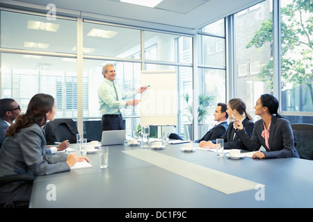 Imprenditore incontro leader a lavagna in sala conferenze Foto Stock