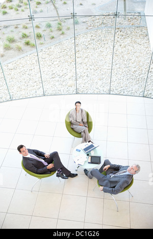 Angolo alto ritratto di uomini di affari che incontro nella lobby Foto Stock