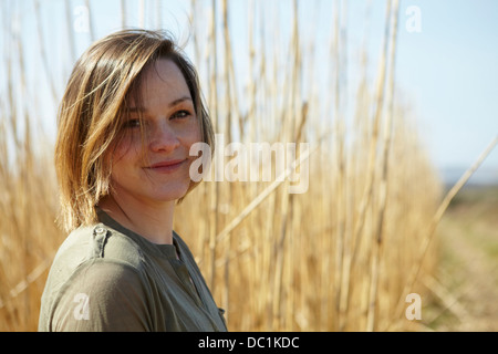 Ritratto di giovane donna di fronte a canne Foto Stock