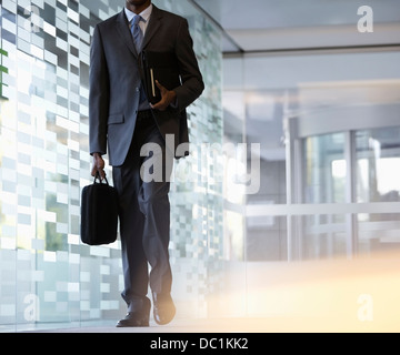 Imprenditore valigetta porta nella lobby Foto Stock