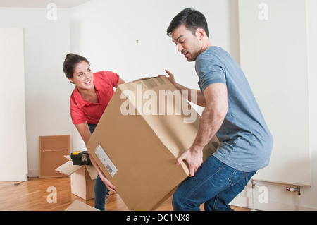 Coppia giovane sollevamento scatola di cartone Foto Stock