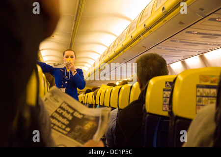 Dimostrazione di sicurezza a bordo di un volo Ryanair alcuni passeggeri ignorano le informazioni portano sul giornale di lettura Foto Stock