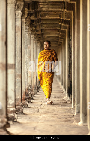 Giovane monaco buddista a piedi attraverso il tempio di Angkor Wat, Siem Reap, Cambogia Foto Stock