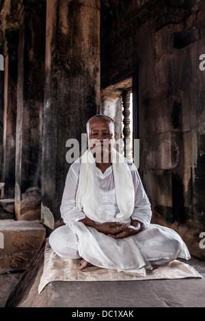 Senior monaco buddista meditando nel tempio di Angkor Wat, Siem Reap, Cambogia Foto Stock