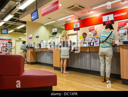 Ufficio postale contatore con persone in attesa a Exeter Devon, Inghilterra Foto Stock