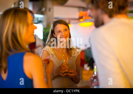 Gli amici sorseggiando un drink insieme in bar Foto Stock