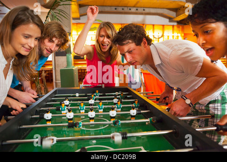 Gruppo di amici a giocare il calcio balilla Foto Stock