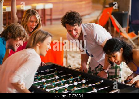 Gli amici di divertirsi giocando a calcio balilla Foto Stock