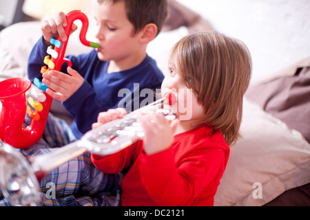 Due giovani bambini che giocano gli strumenti giocattolo Foto Stock