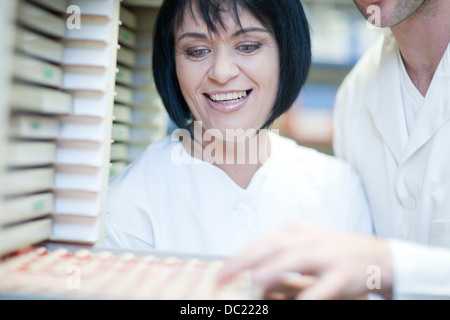 Odontotecnici scegliendo dente impiallacciature in laboratorio Foto Stock