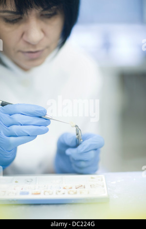 Odontotecnico lavorando sul dente finto Foto Stock