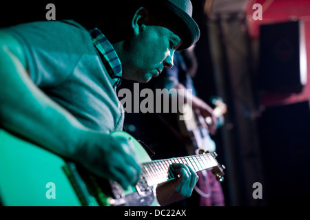 Uomo a suonare la chitarra sul palco in discoteca Foto Stock