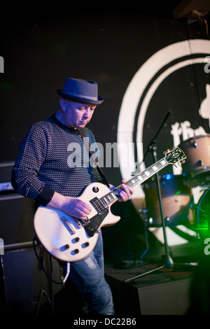 Uomo maturo a suonare la chitarra sul palco Foto Stock